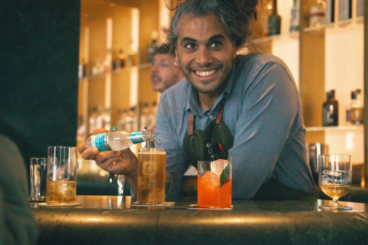 a man sitting at a bar pouring a drink at Sea Containers London in London