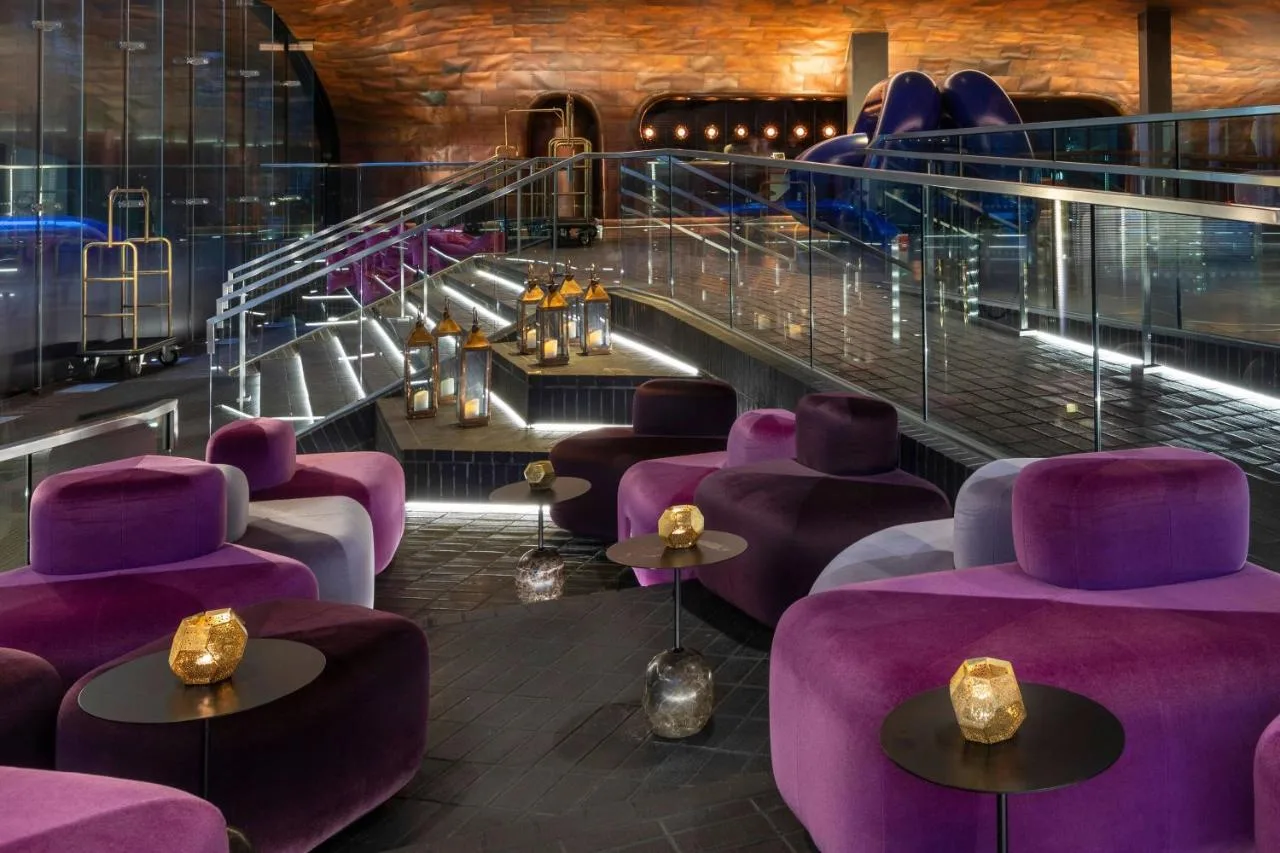 a restaurant with purple seating and stairs at Sea Containers London in London