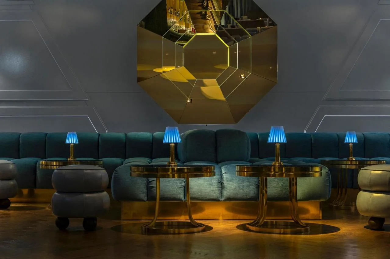 a lobby with a blue couch and two tables at Sea Containers London in London